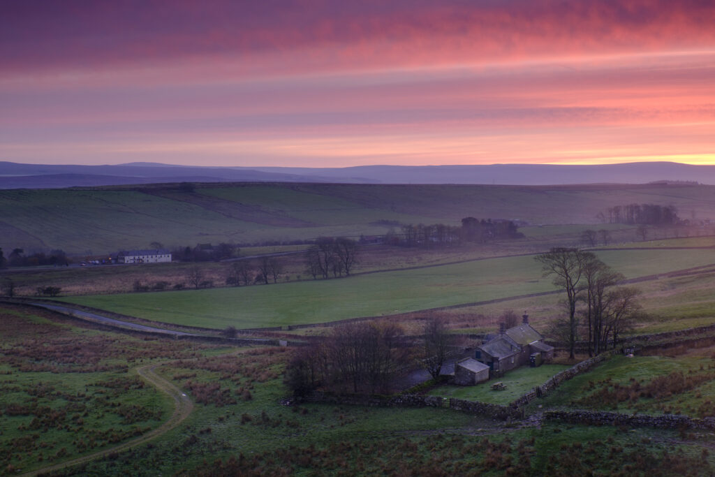 England, Northumberland, Hadrians Wall. Peel Bothy near Steel Rigg viewed from near Hadrians Wall as it runs along Peel Crags.