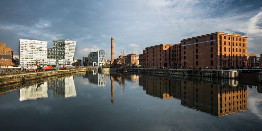 England, Merseyside, Liverpool. Merseyside Maritime Museum and surrounding buildings reflected in the still waters of the Liverpool Albert Docks.