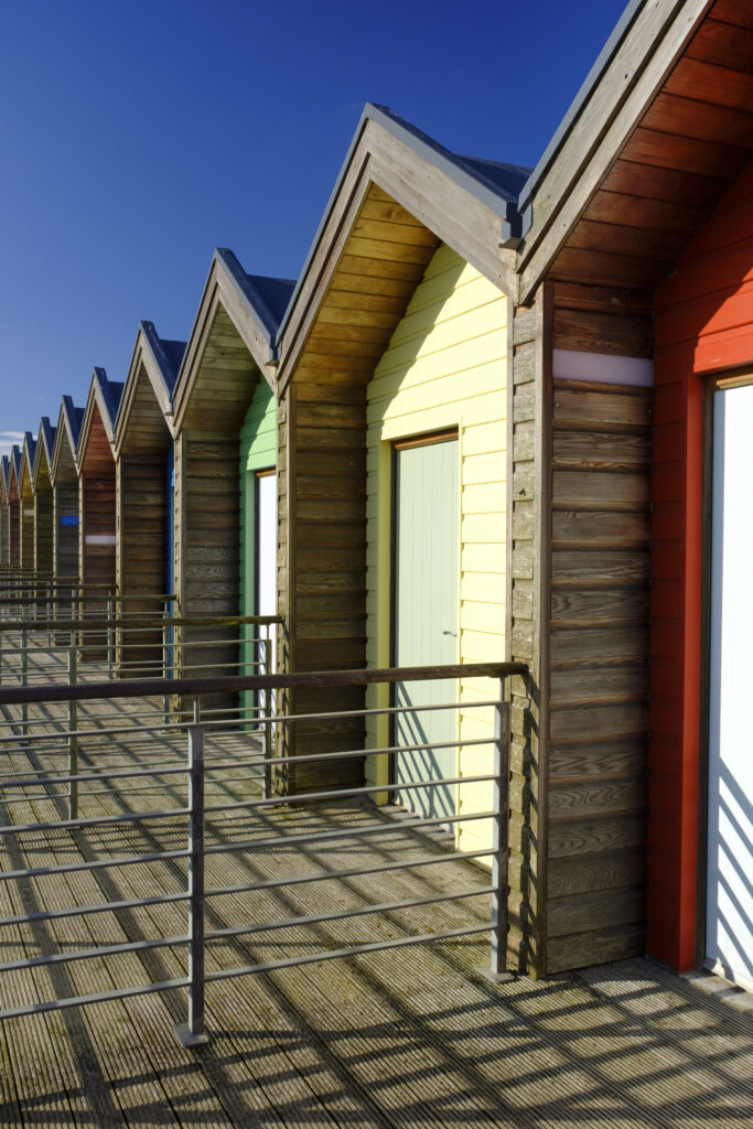 England, Northumberland, Blyth. Colourful beach huts on the promenade at Blyth Beach.