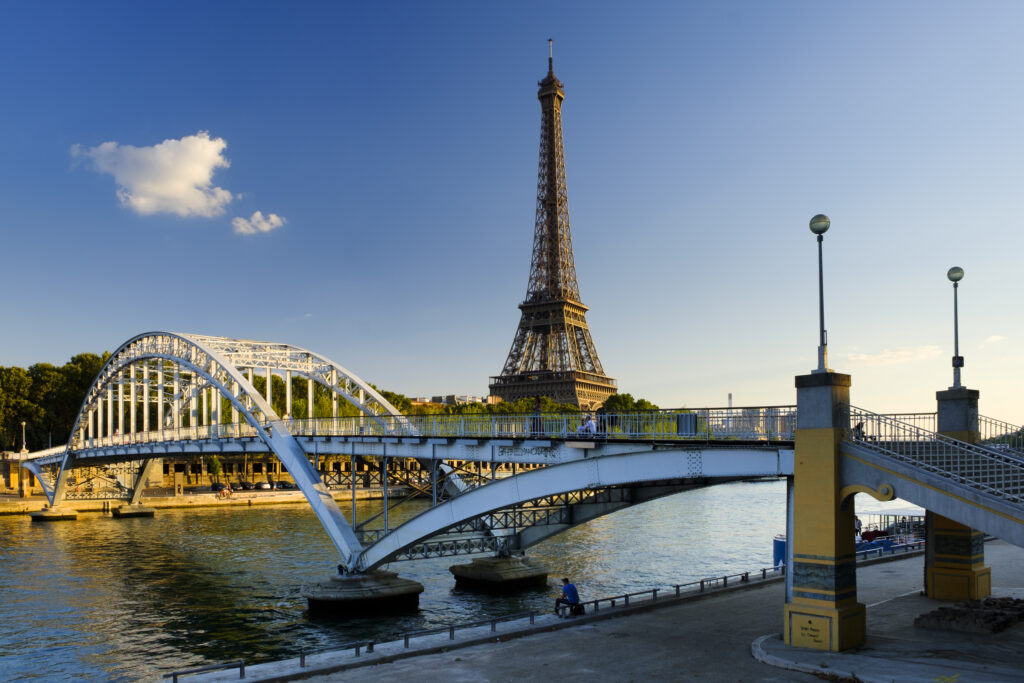 France, Paris, Eiffel Tower. Evening light on the Eiffel Tower and the Passerelle Debilly, a footbridge spanning the River Seine which runs through Paris, the French capital city.