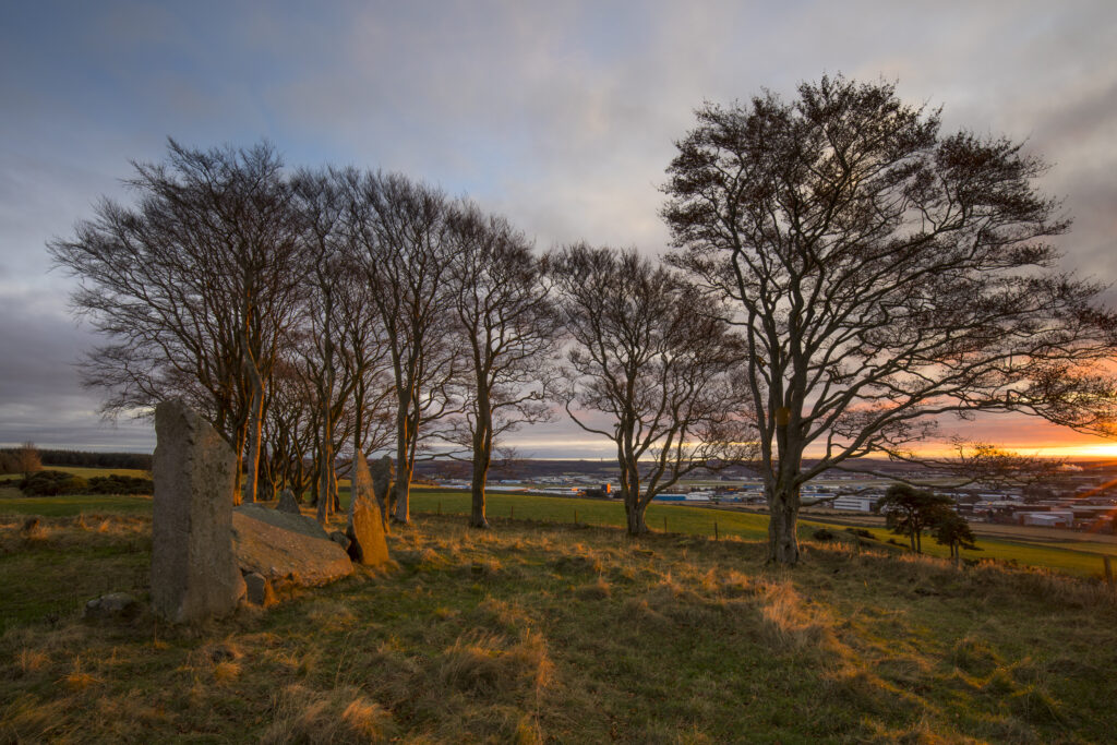 Scotland, Aberdeenshire, Tyrebagger Stone Circle. First light of the day illuminates the recumbent stone circle at Tyrebagger on the outskirts of Aberdeen over looking the Airport.