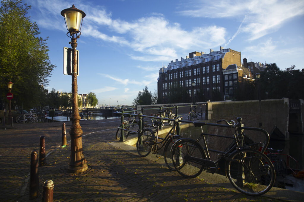 Netherlands, North Holland, Amsterdam. Early morning scene of bicycles left by a canal near Oude Waal in Amsterdam City.