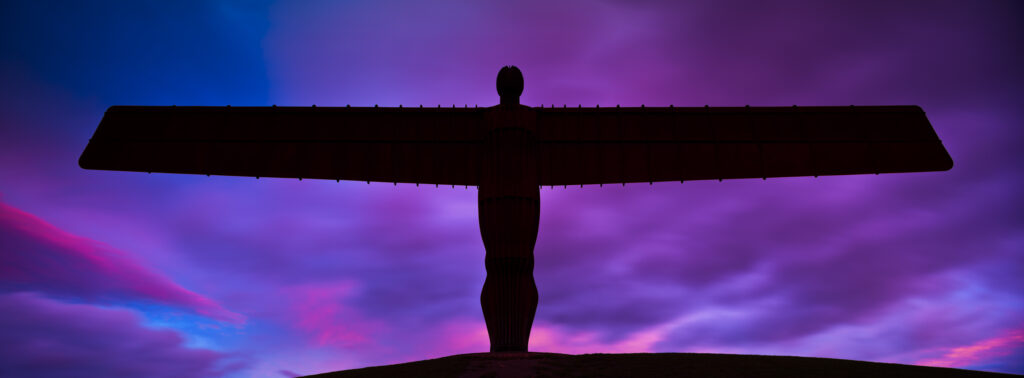 England, Tyne and Wear, Gateshead. The iconic Angel of the North statue by Antony Gormley, silhouetted against an atmospheric sky. The 'Angel', built on a a former colliery pit head bath site, is one of the worlds most viewed work of art with over 33 million viewers each year.