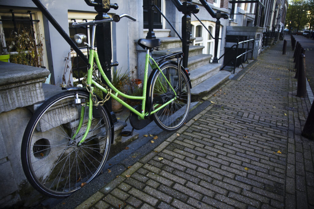 Netherlands, North Holland, Amsterdam. Bicycles chained to railings outside a building in Amsterdam City.