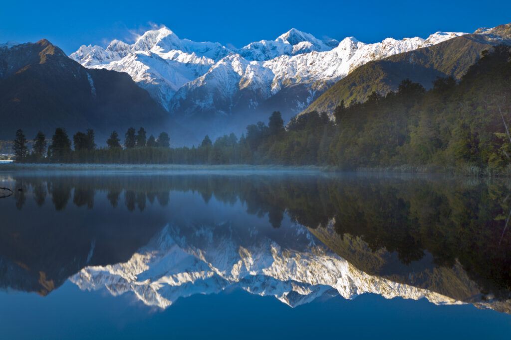 New Zealand, Westland, Westland National Park. Mt Cook and Mt Tasman reflected in the still waters of Lake Matheson.