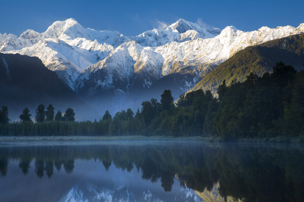 New Zealand, Westland, Westland National Park. Mt Cook and Mt Tasman reflected in the still waters of Lake Matheson.