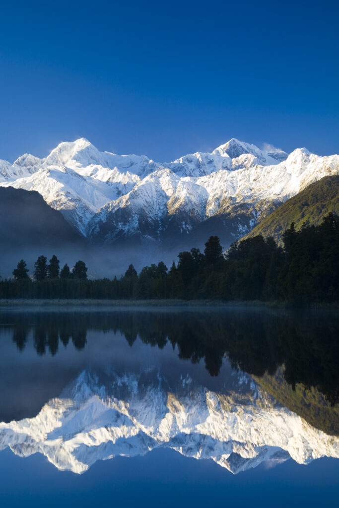 New Zealand, Westland, Westland National Park. Mt Cook and Mt Tasman reflected in the still waters of Lake Matheson.