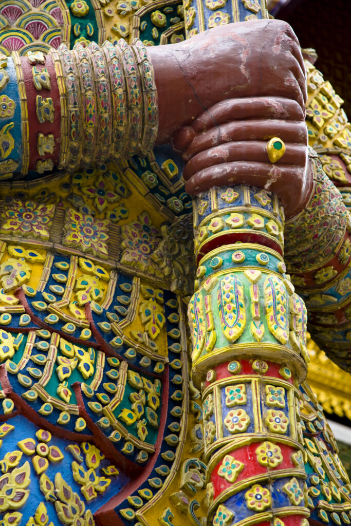 Thailand, Bangkok, The Grand Palace. Statue in the ornate setting of the golden grand palace.