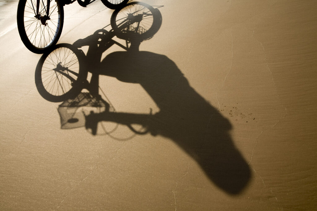 Laos, Si Phan Don (Four Thousand Islands), Don Khon. Female tourist on a hired bicycle on a sandy beach on the island of Don Knon.