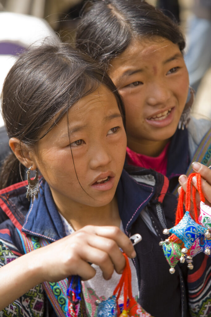 Vietnam, Northern Vietnam, Sapa. Two girls from a local hill tribe trying to sell trinkets to a tourist.