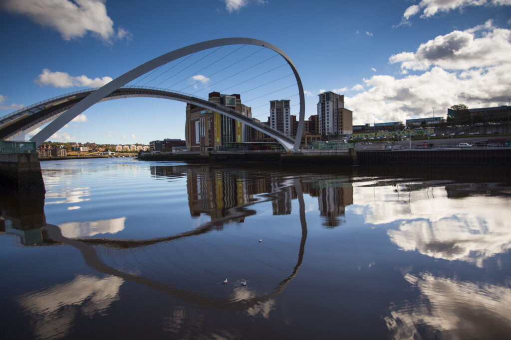 England, Tyne and Wear, Newcastle Upon Tyne. The Gateshead Millenium Bridge in its open position, on the Newcastle Upon Tyne Quayside, with the Baltic Art Gallery in the distance.