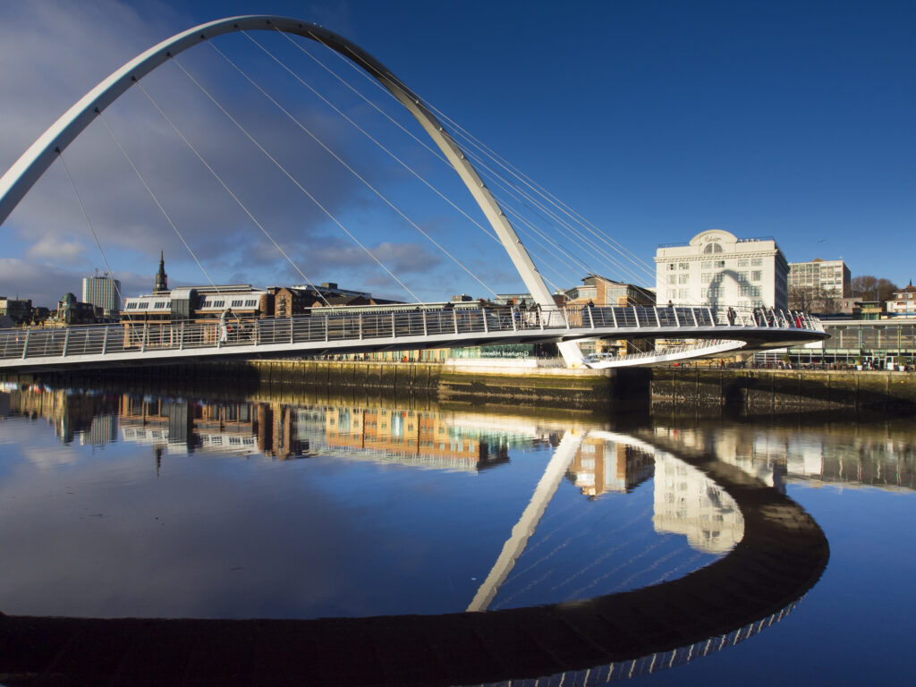 England, Tyne and Wear, Newcastle Upon Tyne. The Gateshead Millennium Bridge, crossing the River Tyne towards the Malmaison hotel in the former cooperative building on the Quayside.