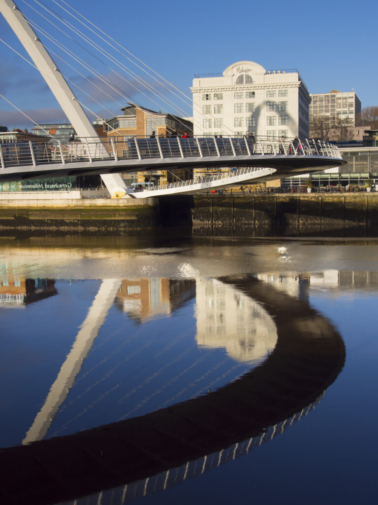 England, Tyne and Wear, Newcastle Upon Tyne. The Gateshead Millennium Bridge, crossing the River Tyne towards the Malmaison hotel in the former cooperative building on the Quayside.