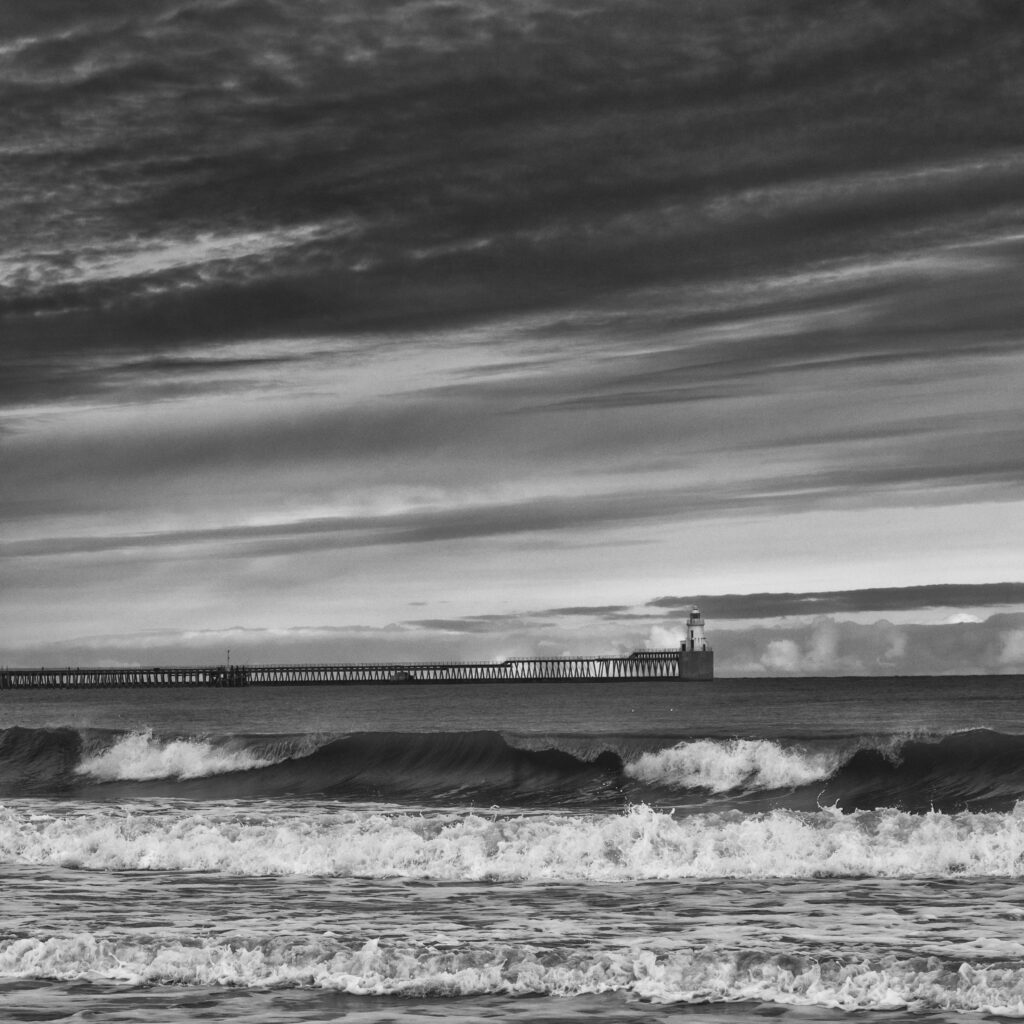 England, Northumberland, Blyth. Blyth Pier and lighthouse viewed from Blyth South Beach.