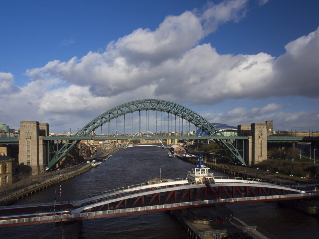 England, Tyne & Wear, Newcastle Upon Tyne. Elevated view of the River Tyne, Sage Building, Millennium Bridge and Tyne Bridge with the Swing Bridge in the foreground.