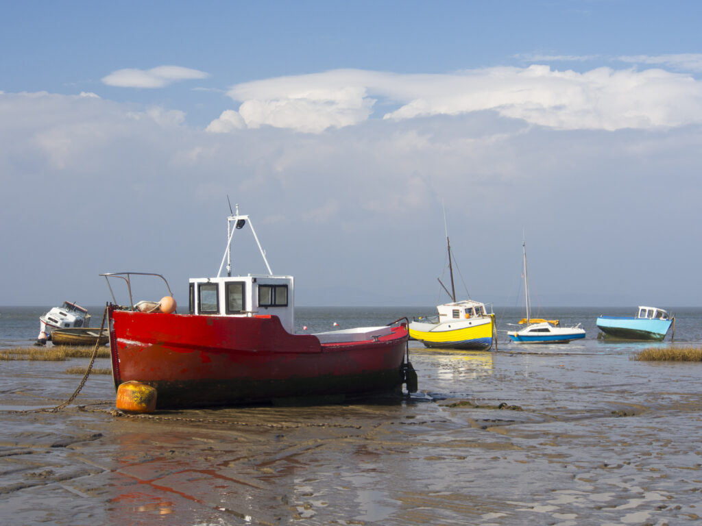 England, Lancashire, Morecambe. Fishing boats at low tide moored at Morecambe / Morecambe Bay.