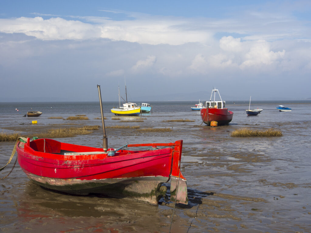 England, Lancashire, Morecambe. Fishing boats at low tide moored at Morecambe / Morecambe Bay.