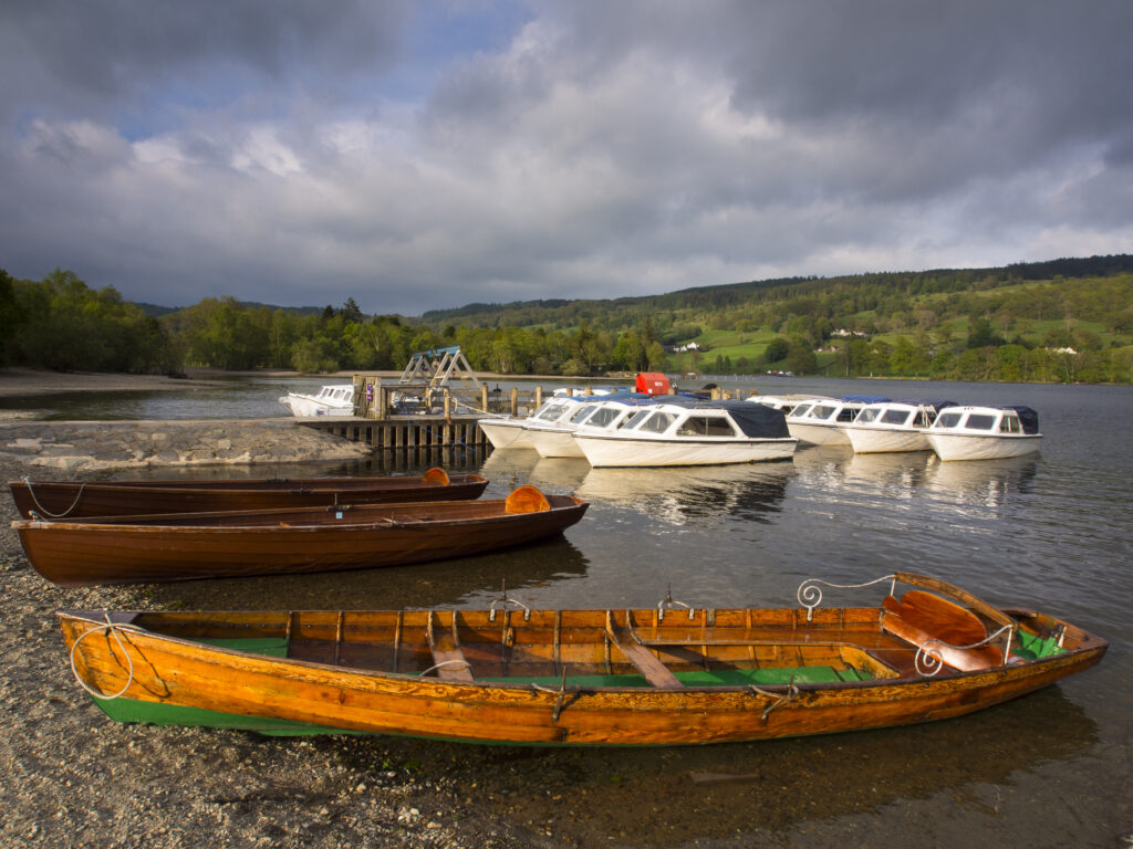 England, Cumbria, Lake District National Park. Rowing boats moored on the lake side of Coniston Water.
