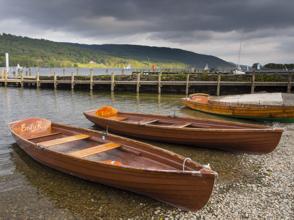 England, Cumbria, Lake District National Park. Rowing boats moored on the lake side of Coniston Water.