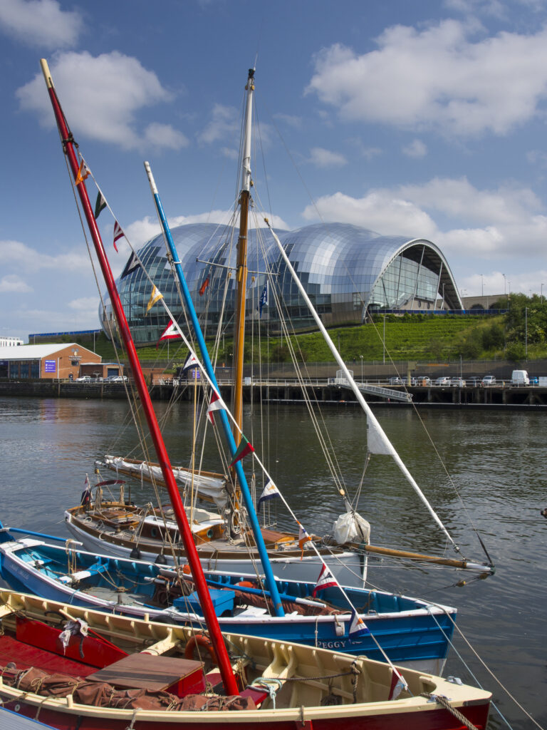 England, Tyne and Wear, Newcastle upon Tyne. Sailing boats moored alongside the Newcastle upon Tyne Quayside with the Sage Music Concert Hall Building behind.