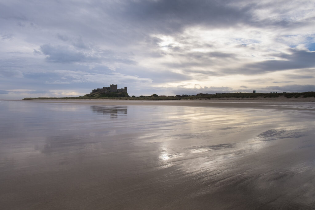 England, Northumberland, Bamburgh.Early morning on the sandy beach near Bamburgh overlooked by Bamburgh Castle, located along the Northumberland Heritage Coast.