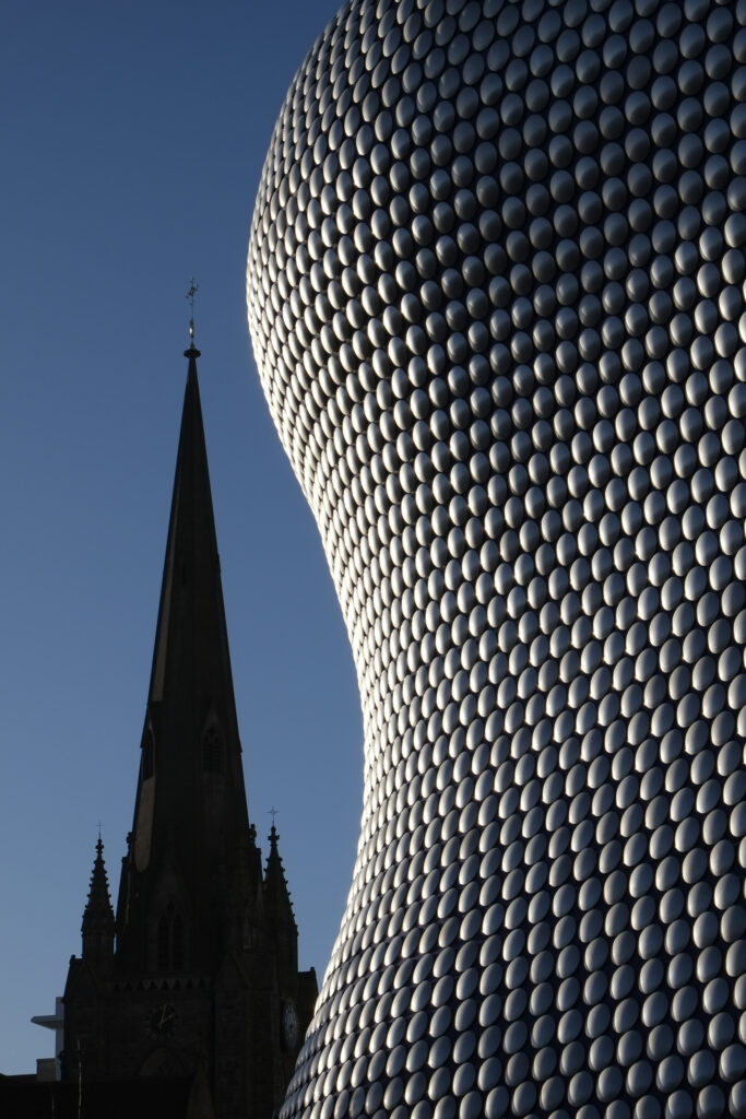 England, West Midlands, Birmingham City. Abstract shapes of the new, modern Selfridges building, alongside the old St Martins Church.