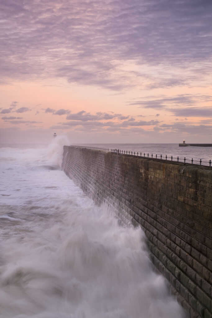 England, Tyne and Wear, Tynemouth. Waves crash at the mouth of the River Tyne, during a winter storm.