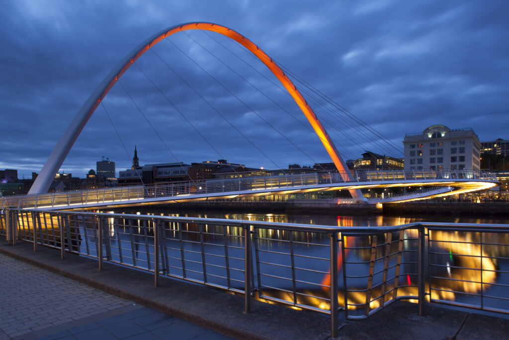 England, Tyne and Wear, Gateshead. The Gateshead Millennium Bridge, crossing the River Tyne towards the Malmaison hotel in the former cooperative building on the Newcastle Upon Tyne Quayside.