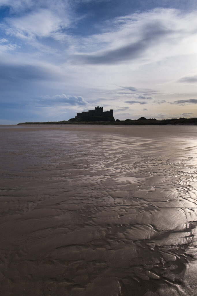England, Northumberland, Bamburgh.Early morning on the sandy beach near Bamburgh overlooked by Bamburgh Castle, located along the Northumberland Heritage Coast.