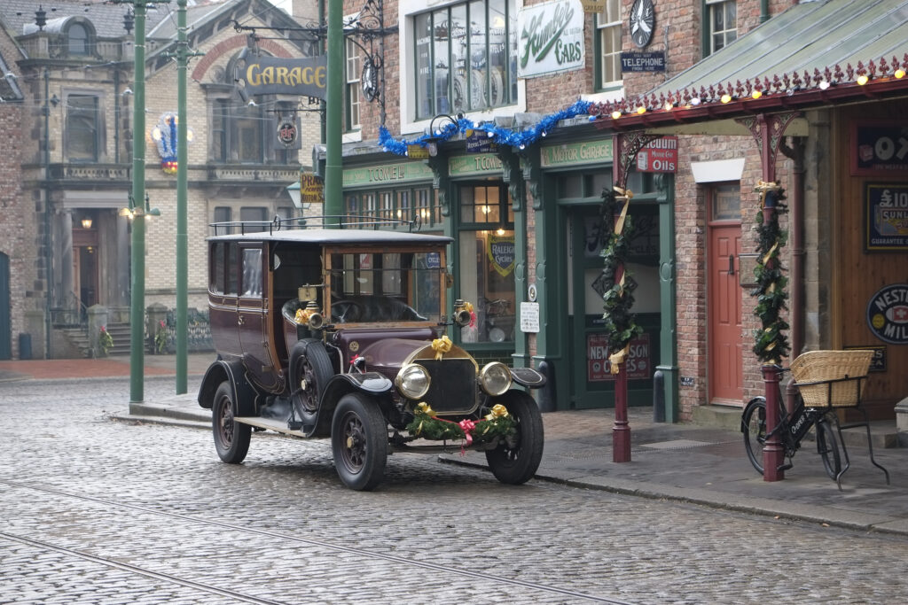 England, Tyne & Wear, Beamish Museum. Vintage car parked in a vintage street at the Beamish Museum, England, Tyne & Wear, Beamish Museum. Christmas decoraions on a tram at the Beamish Museum, a world famous museum telling the story of the people of North East England during the Georgian, Victorian, and Edwardian periods.