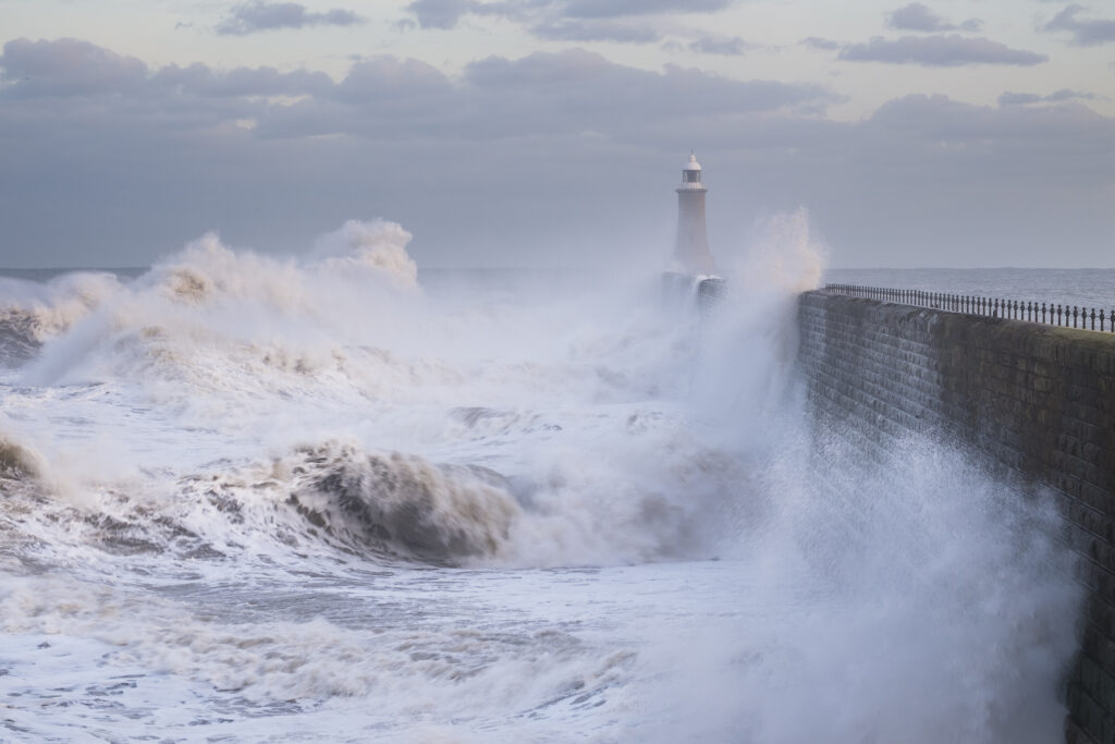 England, Tyne and Wear, Tynemouth. Waves crash at the mouth of the River Tyne, during a winter storm.