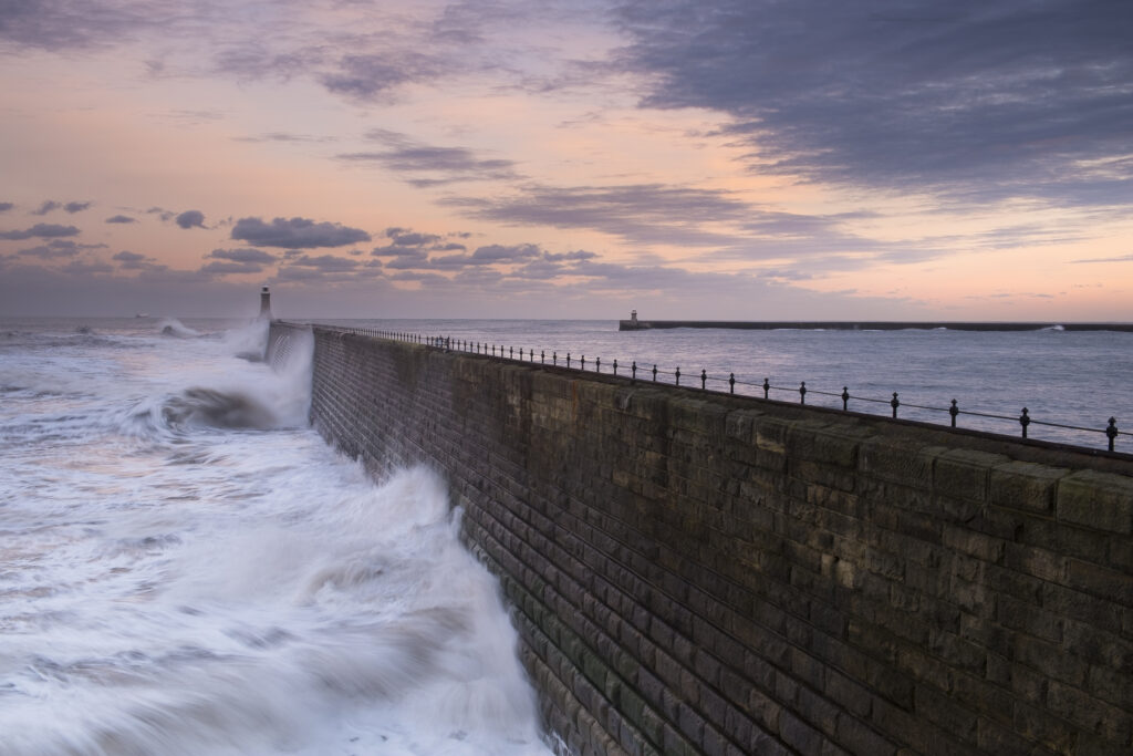England, Tyne and Wear, Tynemouth. Waves crash at the mouth of the River Tyne, during a winter storm.