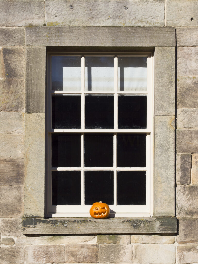 England, Tyne and Wear, Gibside Estate. Carved pumpkin on a window, part of the Halloween celebrations at the National Trust Gibside Estate.