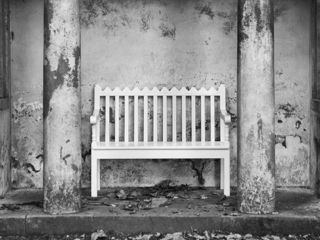 England, Nottinghamshire, Clumber Park. Wooden bench in a stone shelter at Clumber Park, a popular National Trust property on the edge of the historic Sherwood Forest.