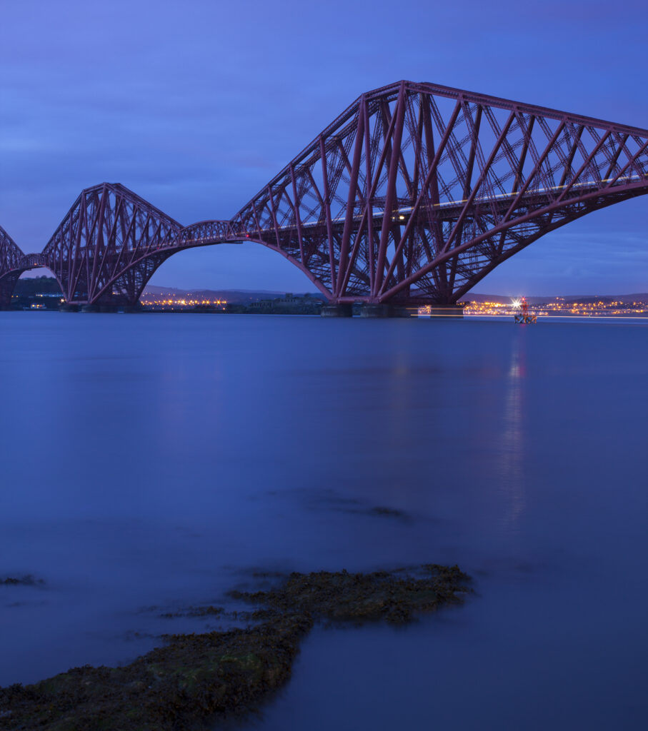 Scotland, Edinburgh, Forth Bridge. Forth Railway Bridge connecting Scotland's capital city, Edinburgh, with Fife, leaving the Lothians at Dalmeny and arriving in Fife at North Queensferry.