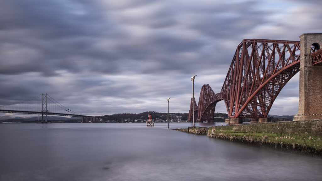 Scotland, Edinburgh, Forth Bridge. Forth Railway Bridge connecting Scotland's capital city, Edinburgh, with Fife, leaving the Lothians at Dalmeny and arriving in Fife at North Queensferry.