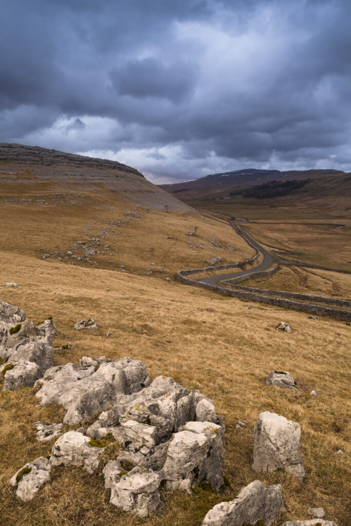 England, North Yorkshire, Yorkshire Dales National Park. Limestone pavement in Kingsdale, with a small country road in the distance.