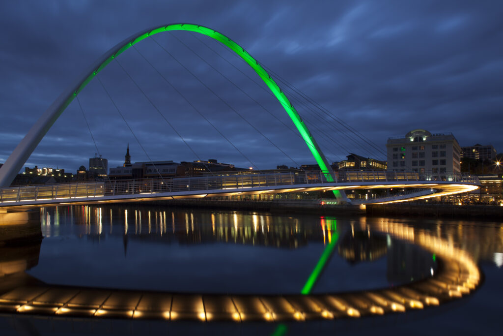 England, Tyne and Wear, Gateshead. The Gateshead Millennium Bridge, crossing the River Tyne towards the Malmaison hotel in the former cooperative building on the Newcastle Upon Tyne Quayside.