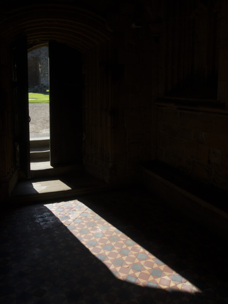 England, Tyne and Wear, Tynemouth Castle and Priory. Open doorway illuminates the tiled floor of the chapel - part of Tynemouth Priory.
