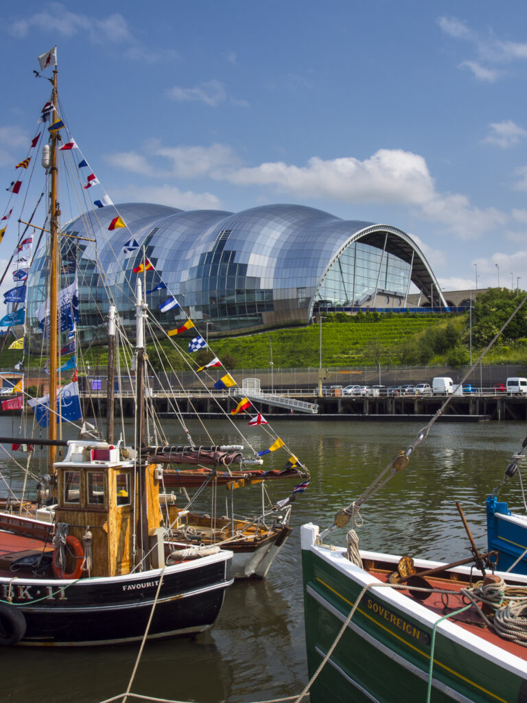 England, Tyne and Wear, Newcastle upon Tyne. Sailing boats moored alongside the Newcastle upon Tyne Quayside with the Sage Music Concert Hall Building behind.