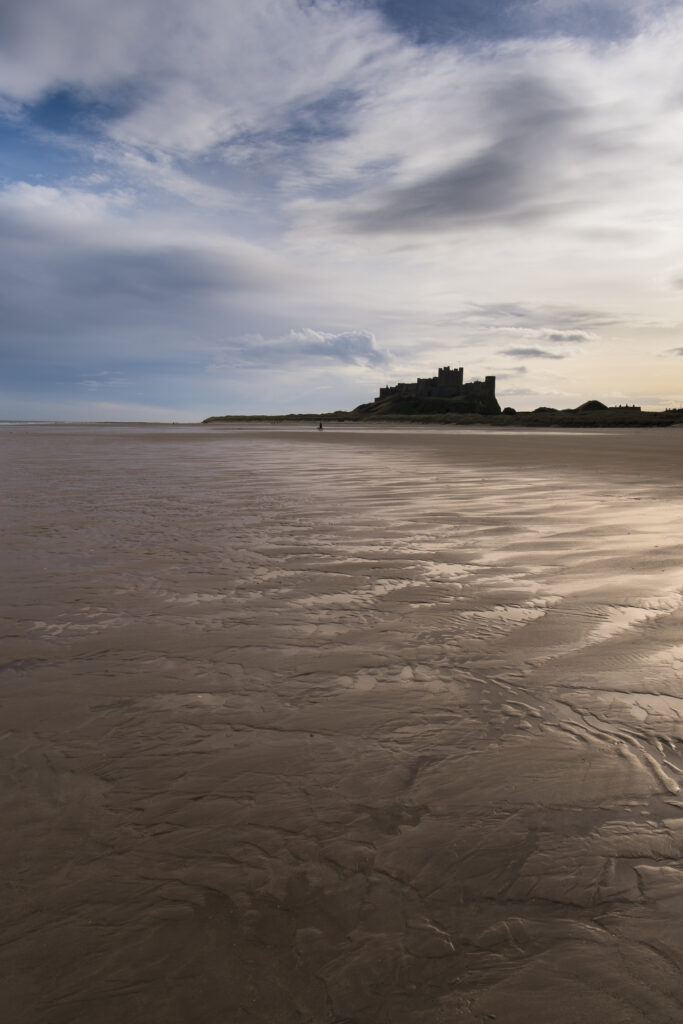 England, Northumberland, Bamburgh.Early morning on the sandy beach near Bamburgh overlooked by Bamburgh Castle, located along the Northumberland Heritage Coast.