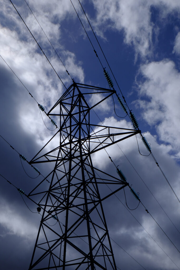 Scotland, Scottish Highlands, Cairngorms National Park. Electricity pylon with storm clouds above.