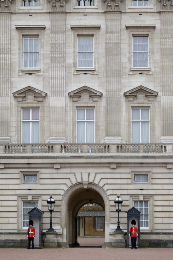 England, Greater London, City of Westminster. Queens' Guard standing alongside an archway forming part of Buckingham Palace.
