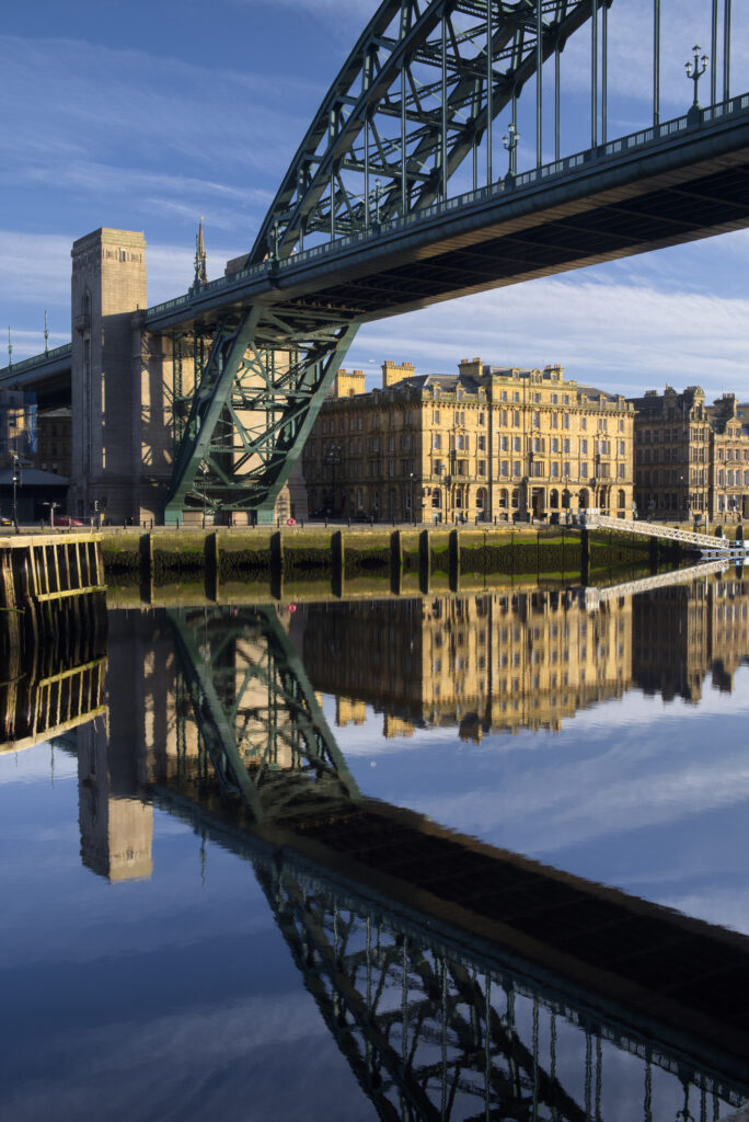 England, Tyne and Wear, Newcastle Upon Tyne. The world famous Tyne Bridge and Newcastle Upon Tyne Quayside reflected in the still waters of the River Tyne.