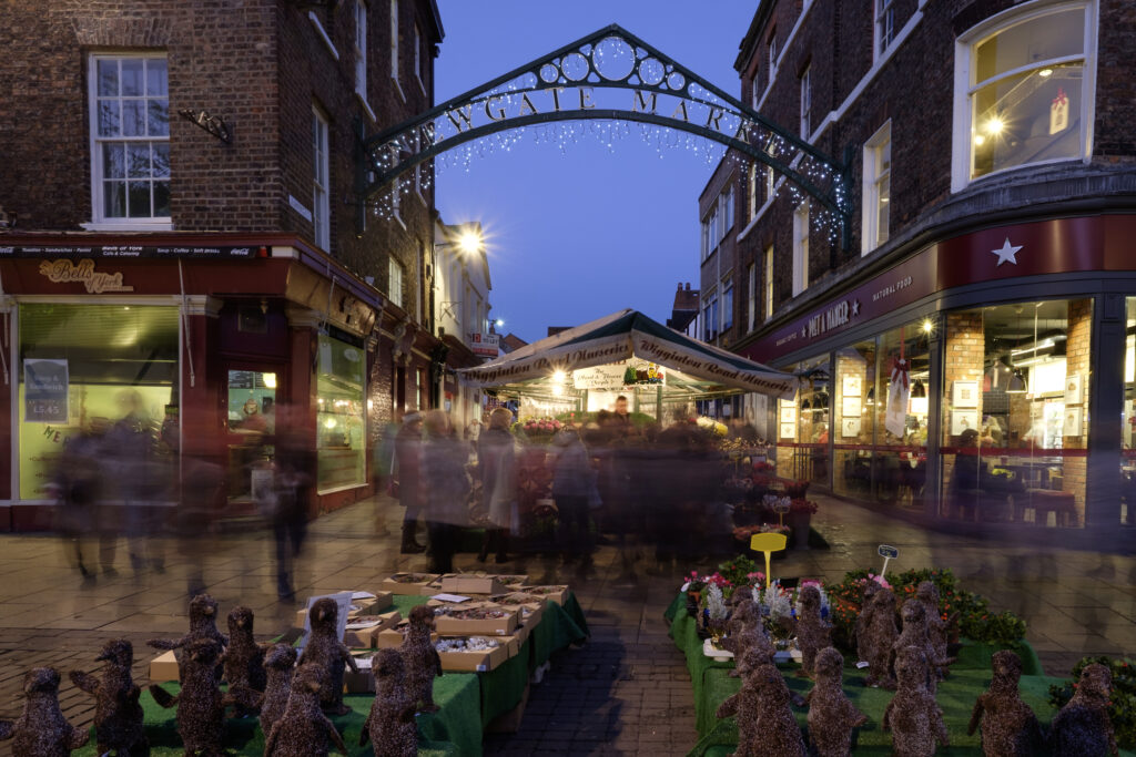 England, North Yorkshire, York City. Entrance to Newgate Christmas Market seen from Parliament Street.