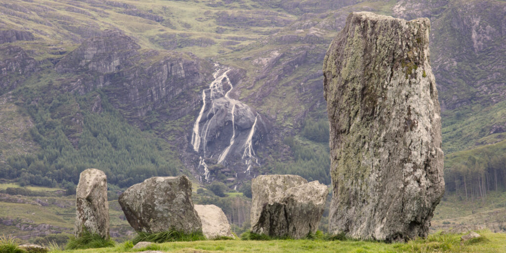 Republic of Ireland, County Kerry, Uragh Stone Circle. Waterfall behind the prehistoric Uragh Stone Circle which is located between Lough Inchiquin and Lough Cloonee in Gleninchiquin Park, on the Beara Peninsula.