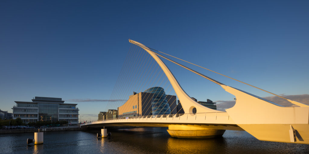 Republic of Ireland, County Dublin, Dublin City. The Samuel Beckett Bridge over the river Liffey with the National Convention Centre behind.