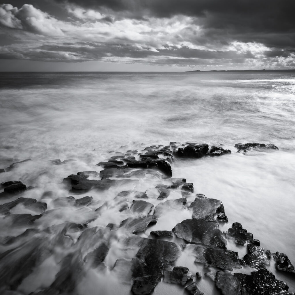 England, Northumberland, Beadnell. The imposing ruins of Dunstanburgh Castle viewed from Beadnell.