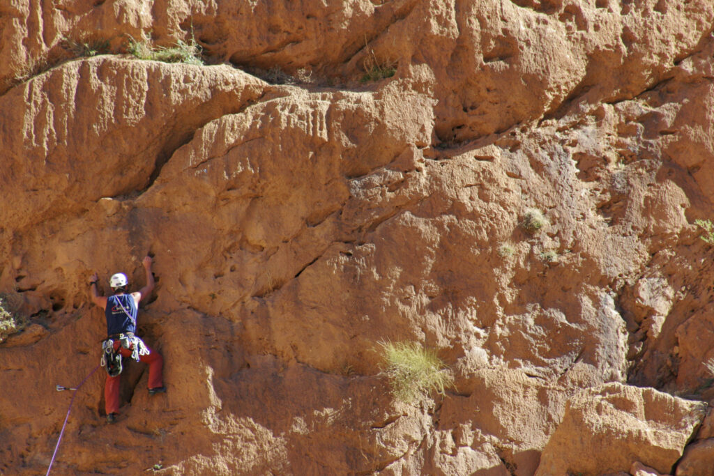 Morocco, Central Morocco, Todra Gorge. A climber continues to climb the sheer face of the Todra Gorge.