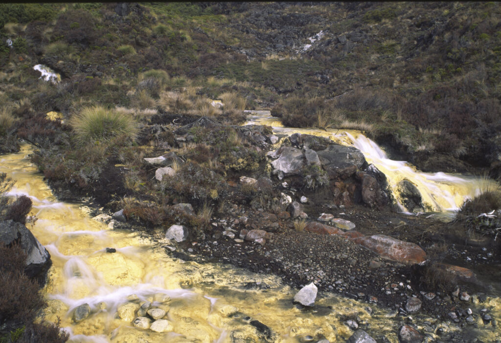 NEW ZEALAND, Central Plateau, Tongariro National Park. The golden waters of Silica rapids formed by Silica mineral deposits